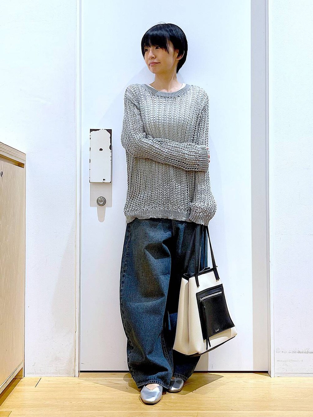 ブルー系のデニムパンツ、ホワイト系のトートバッグ、シルバー系のパンプスを着用したレディースの春コーディネートの2枚目の写真