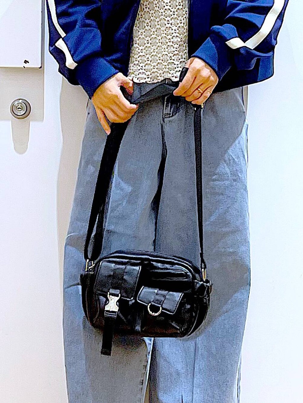 ブルー系のデニムパンツ、ベージュ系のブーツ、ブラック系のショルダーバッグを着用したレディースの冬コーディネートの9枚目の写真