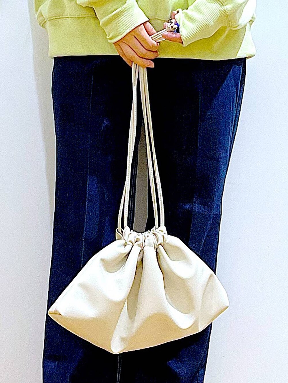 ブルー系のデニムパンツ、イエロー系のスウェット、ベージュ系のブーツを着用したレディースの冬コーディネートの9枚目の写真