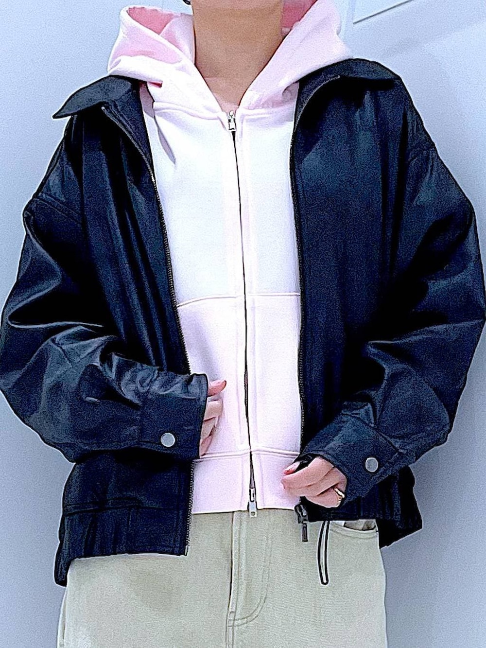 ブラック系のブルゾン、ベージュ系のデニムパンツ、ピンク系のパーカーを着用したレディースの冬コーディネートの7枚目の写真