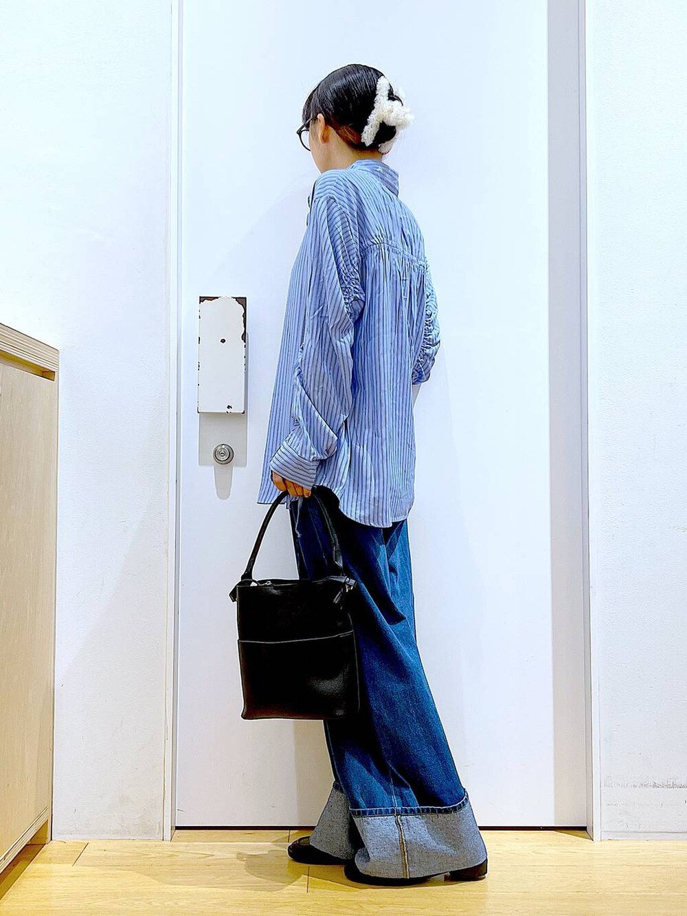 ブラック系のローファー、ブラック系のショルダーバッグ、ブルー系のシャツ/ブラウスを着用したレディースの秋コーディネートの3枚目の写真