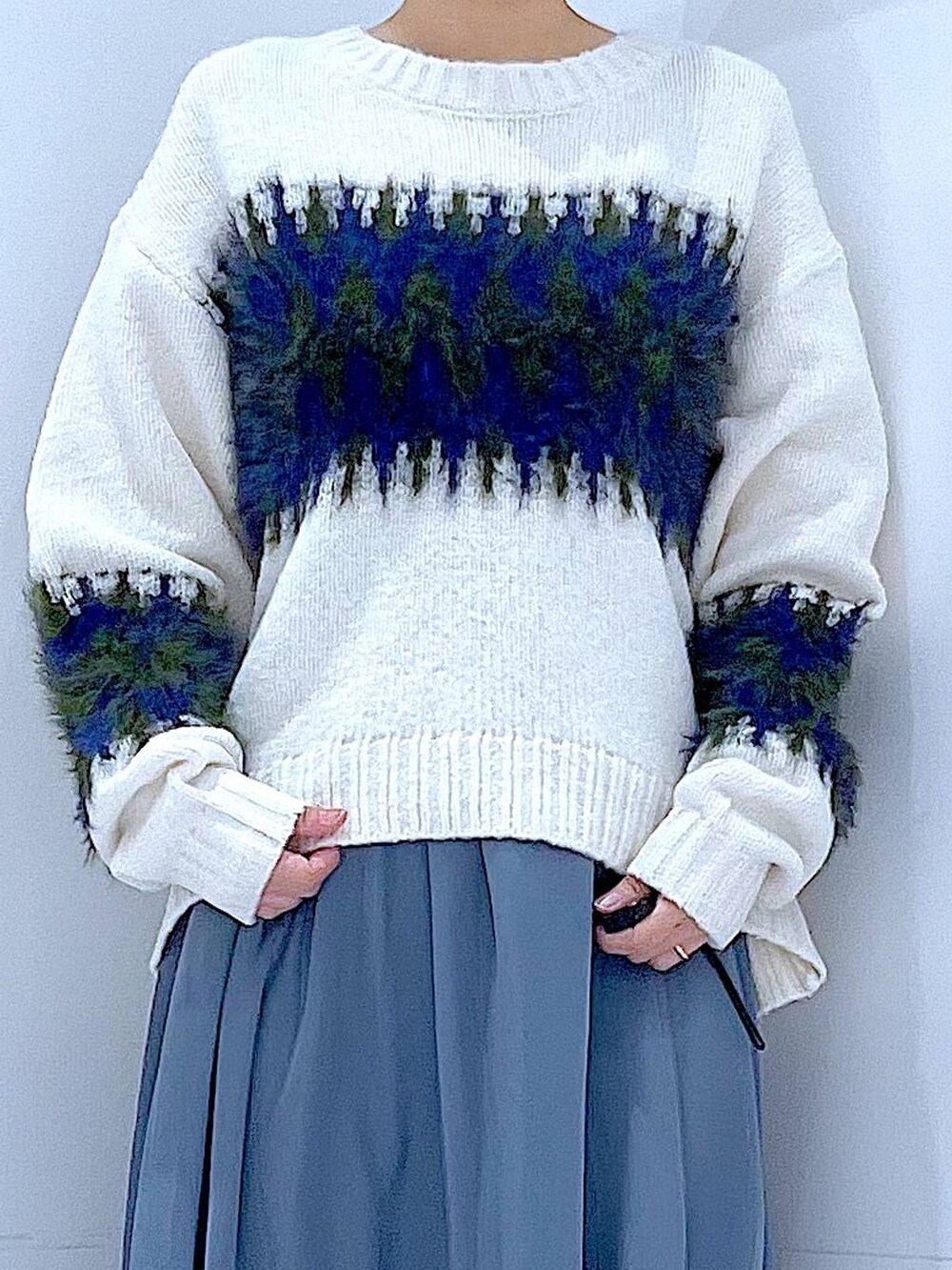 ブラック系のブーツ、ホワイト系のショルダーバッグ、ホワイト系のニット/セーターを着用したレディースの冬コーディネートの7枚目の写真