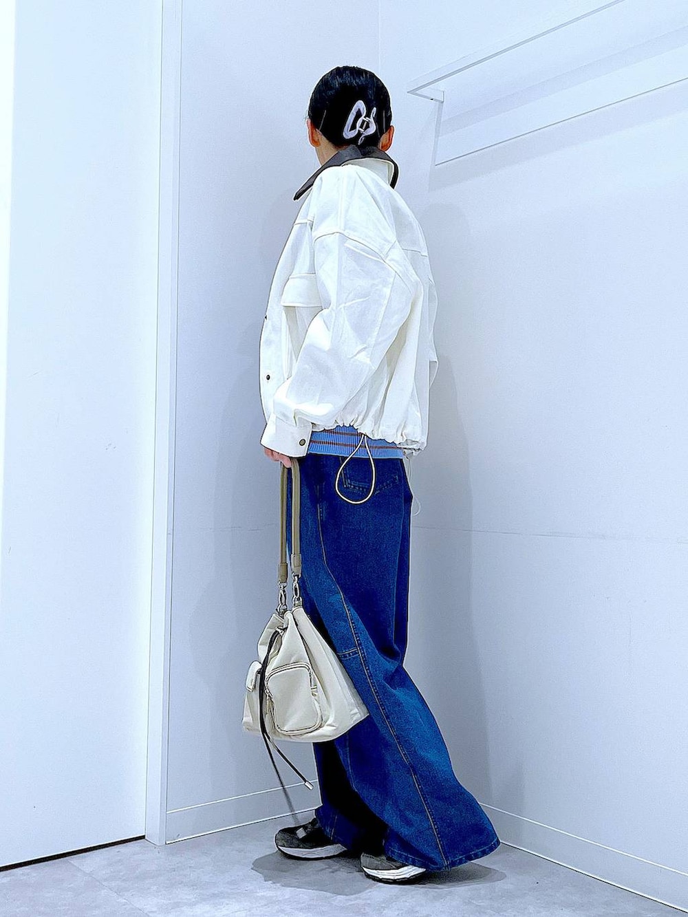 ブルー系のニット/セーター、ブルー系のデニムパンツ、ベージュ系のブルゾンを着用したレディースの冬コーディネートの3枚目の写真