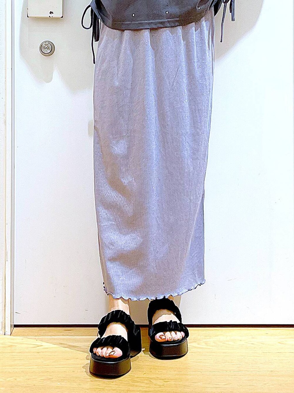 パープル系のスカート、ブラック系のショルダーバッグ、ブラック系のサンダルを着用したレディースの夏コーディネートの8枚目の写真