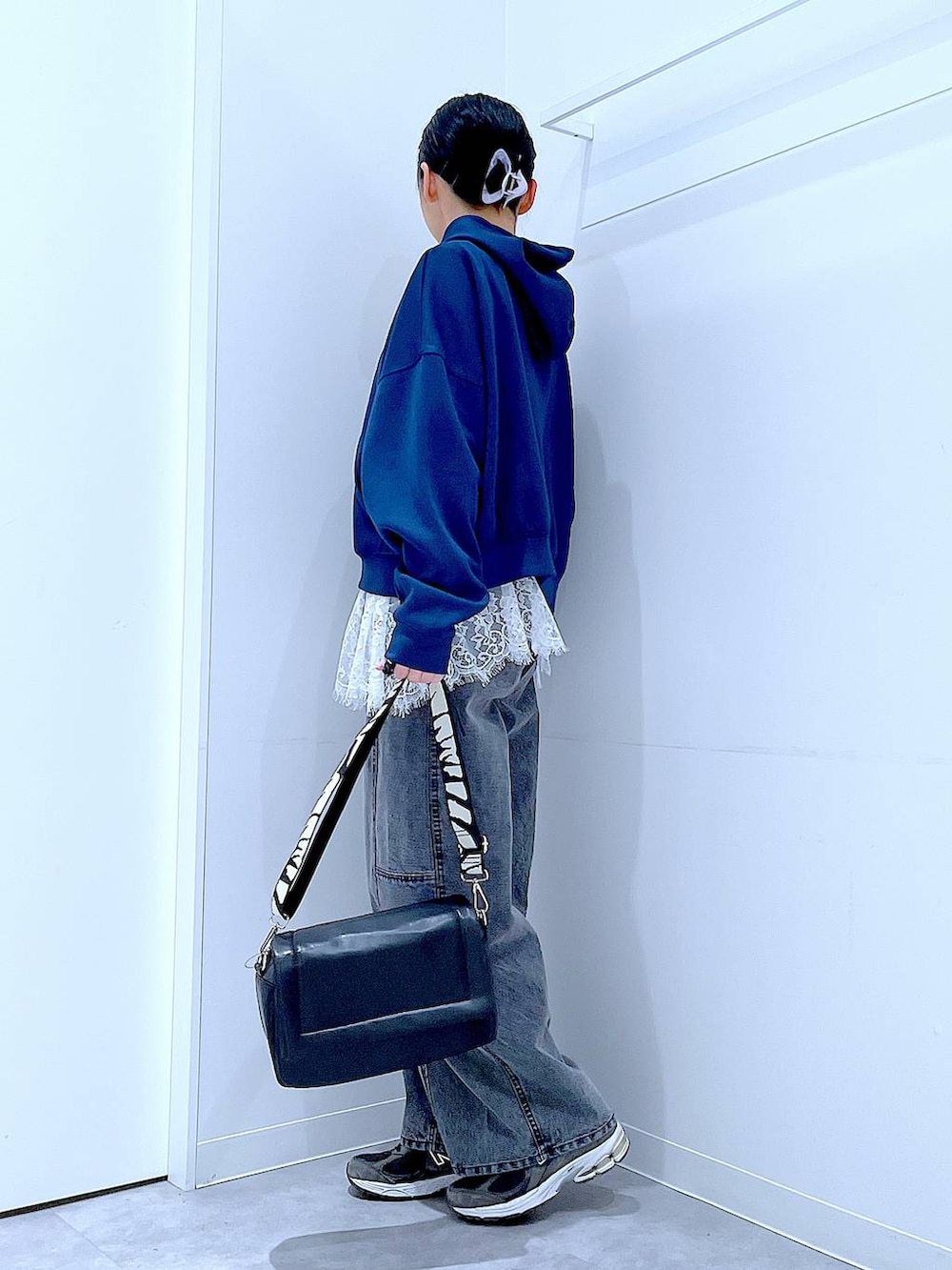 ブラック系のショルダーバッグ、ホワイト系のTシャツ/カットソー、ブラック系のデニムパンツを着用したレディースの春コーディネートの3枚目の写真