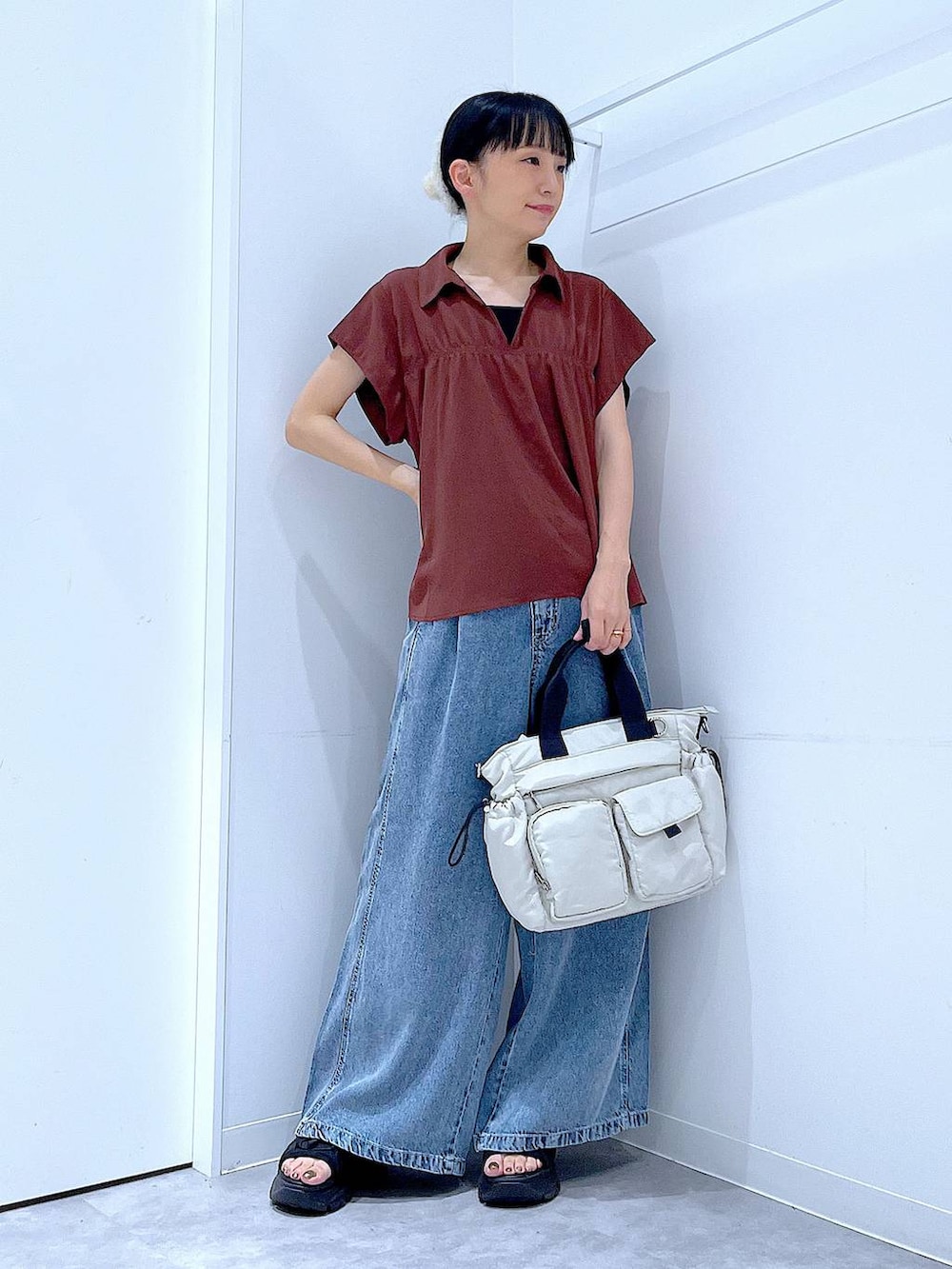 ホワイト系のトートバッグ、ブルー系のデニムパンツ、ブラウン系のシャツ/ブラウスを着用したレディースの夏コーディネートの2枚目の写真