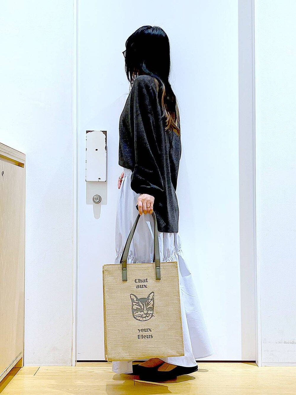 ブルー系のスカート、グレー系のカーディガン/ボレロ、ブラック系のパンプスを着用したレディースの春コーディネートの3枚目の写真