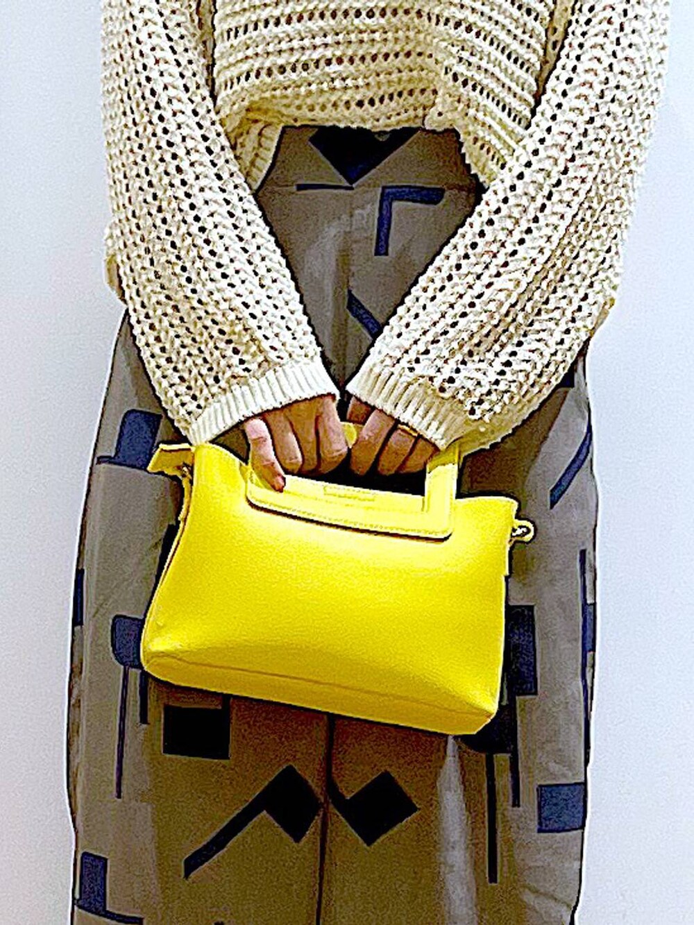 ホワイト系のニット/セーター、イエロー系のショルダーバッグ、ホワイト系のパンプスを着用したレディースの春コーディネートの9枚目の写真