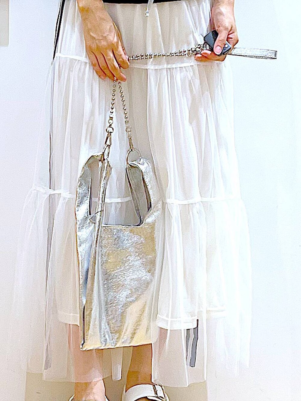 シルバー系のショルダーバッグ、ホワイト系のサンダル、ホワイト系のキャミソールを着用したレディースの夏コーディネートの9枚目の写真