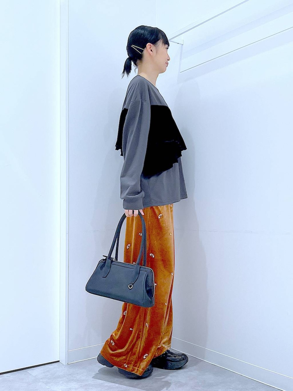 ブラック系のローファー、ブラック系のハンドバッグ、オレンジ系のその他パンツを着用したレディースの秋コーディネートの4枚目の写真