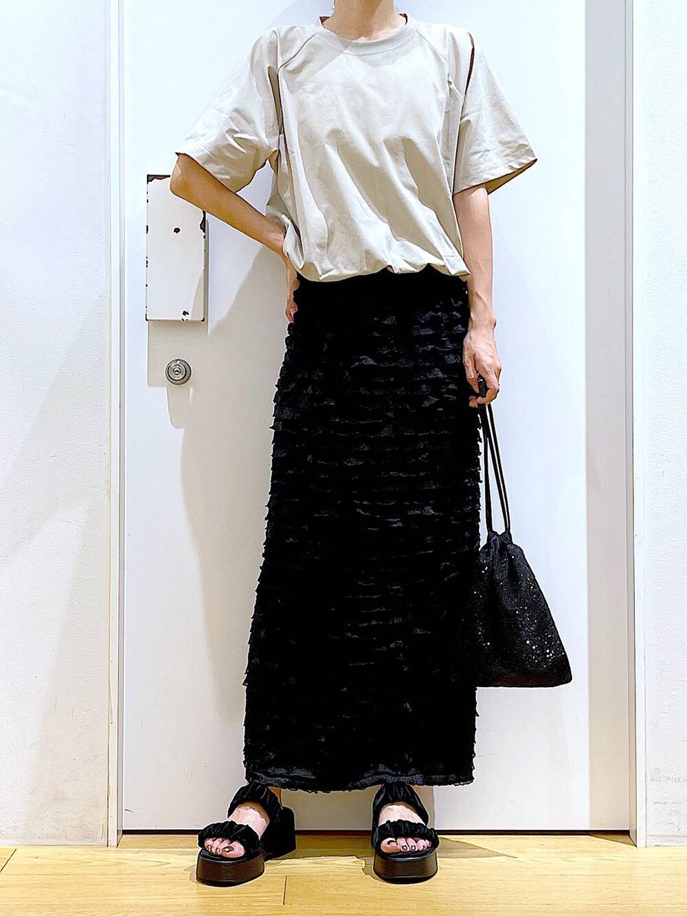 ブラック系のサンダル、グレー系のTシャツ/カットソー、ブラック系のショルダーバッグを着用したレディースの夏コーディネートの6枚目の写真