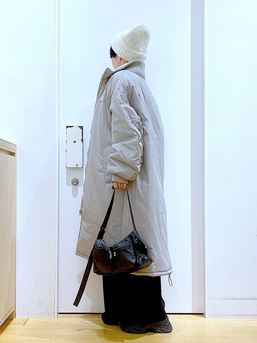 グレー系のミリタリージャケット、ブラック系のブーツ、ブラック系のショルダーバッグを着用したレディースの冬コーディネートの3枚目の写真