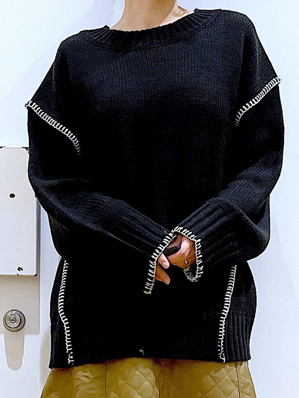 シルバー系のトートバッグ、ベージュ系のブーツ、ブラック系のニット/セーターを着用したレディースの冬コーディネートの7枚目の写真