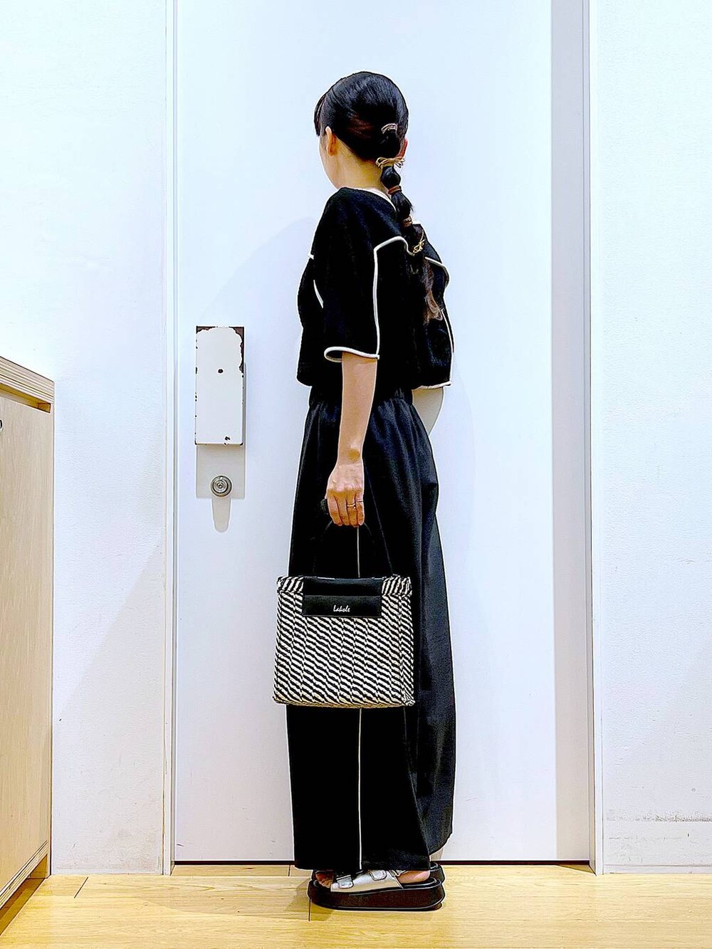 シルバー系のサンダル、ブラック系のショルダーバッグ、ブラック系のその他パンツを着用したレディースの夏コーディネートの3枚目の写真