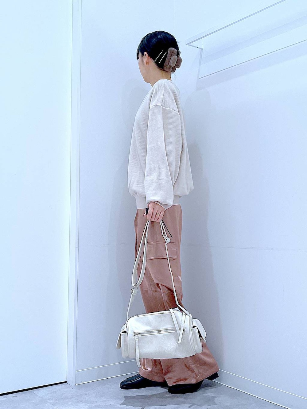 ブラック系のブーツ、ベージュ系のニット/セーター、ピンク系のカーゴパンツを着用したレディースの冬コーディネートの3枚目の写真