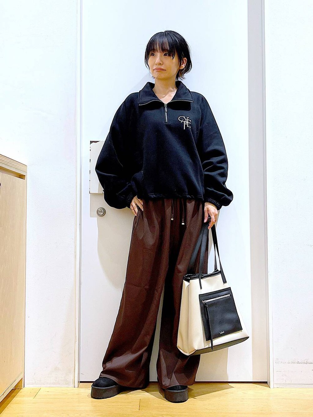 ブラック系のスリッポン、ブラウン系のその他パンツ、ホワイト系のトートバッグを着用したレディースの秋コーディネートの2枚目の写真