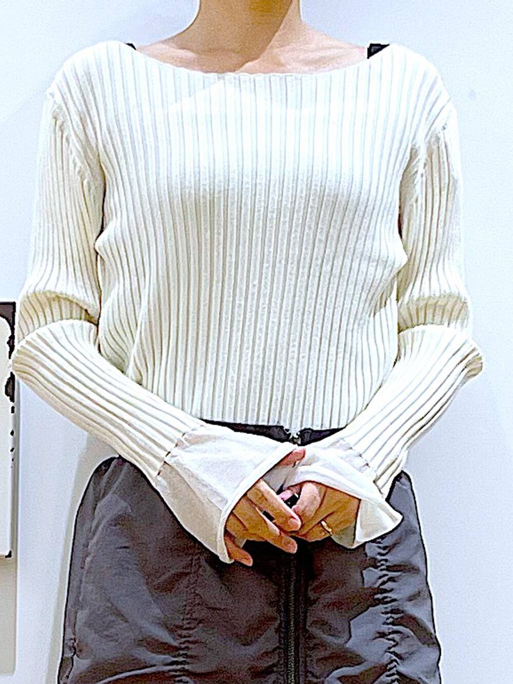 ホワイト系のニット/セーター、ホワイト系のショルダーバッグ、ブラック系のブーツを着用したレディースの秋コーディネートの7枚目の写真