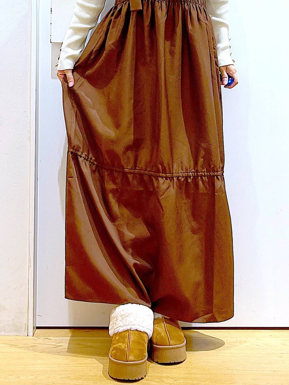 ホワイト系のニット/セーター、ホワイト系のハンドバッグ、ベージュ系のスリッポンを着用したレディースの冬コーディネートの8枚目の写真