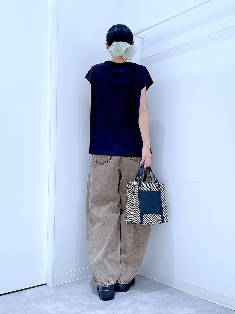 ブラウン系のデニムパンツ、その他のショルダーバッグ、ブラック系のサンダルを着用したレディースの夏コーディネートの5枚目の写真