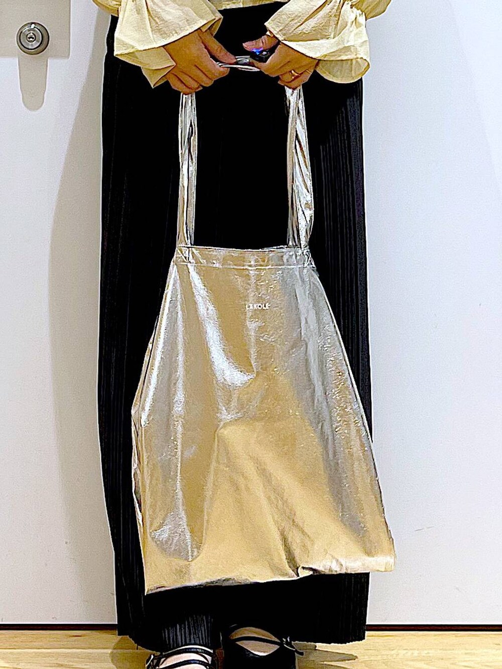 シルバー系のトートバッグ、ブラック系のその他パンツ、ブラック系のパンプスを着用したレディースの秋コーディネートの9枚目の写真