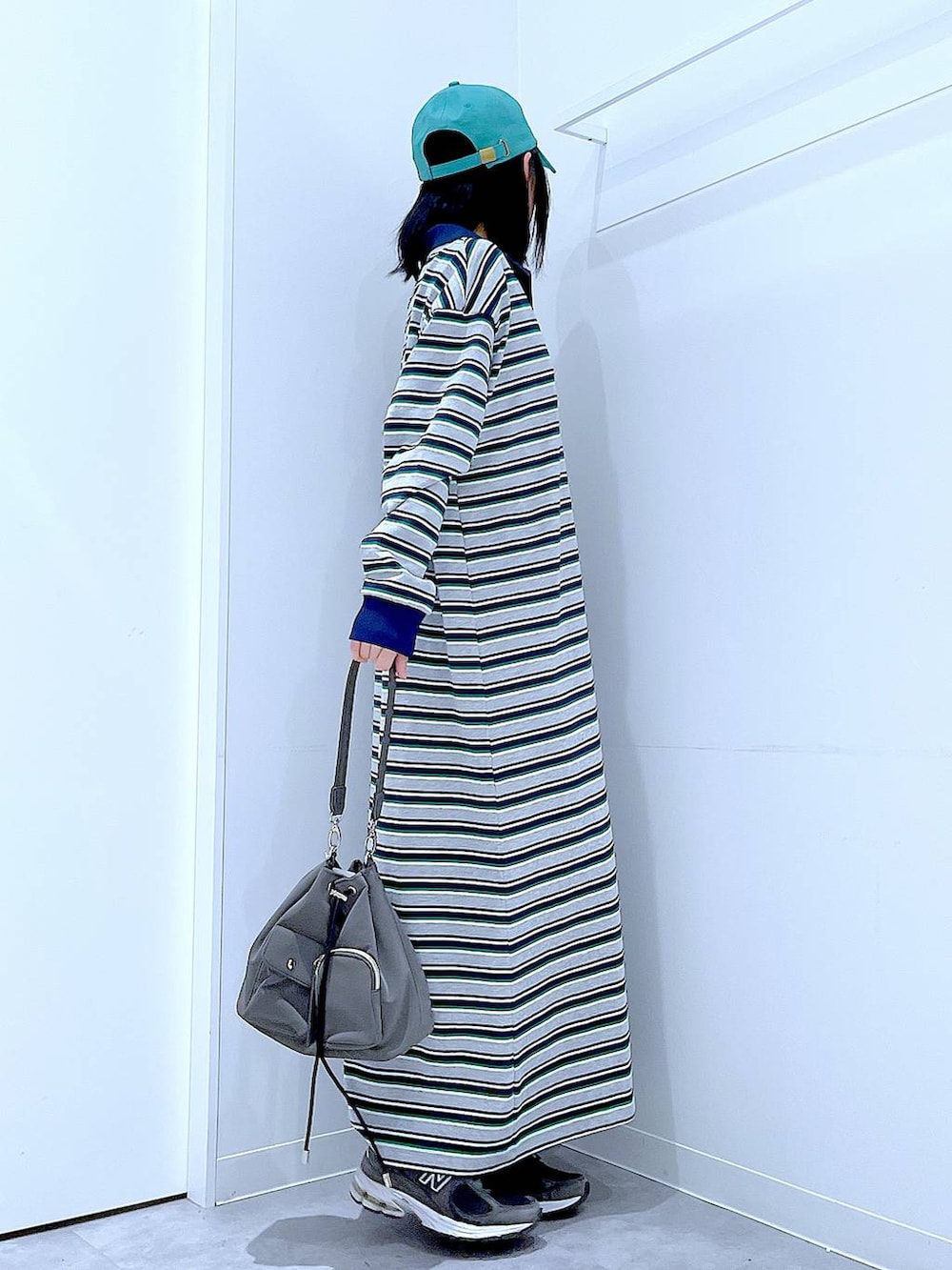 グリーン系のキャップを着用したレディースの春コーディネートの4枚目の写真