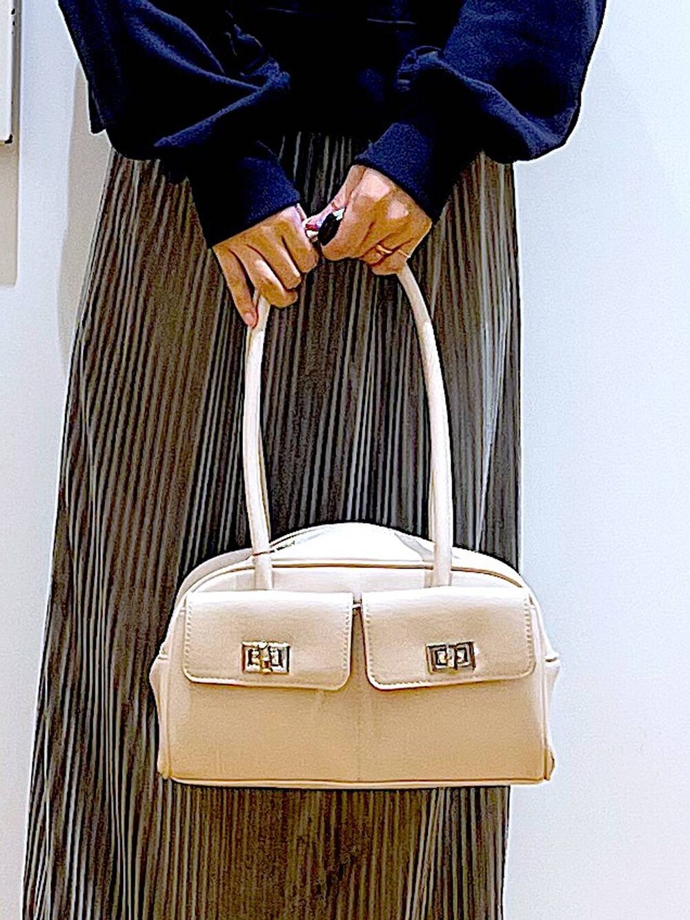 ホワイト系のハンドバッグ、ブラック系のブーツ、ブルー系のスウェットを着用したレディースの秋コーディネートの9枚目の写真