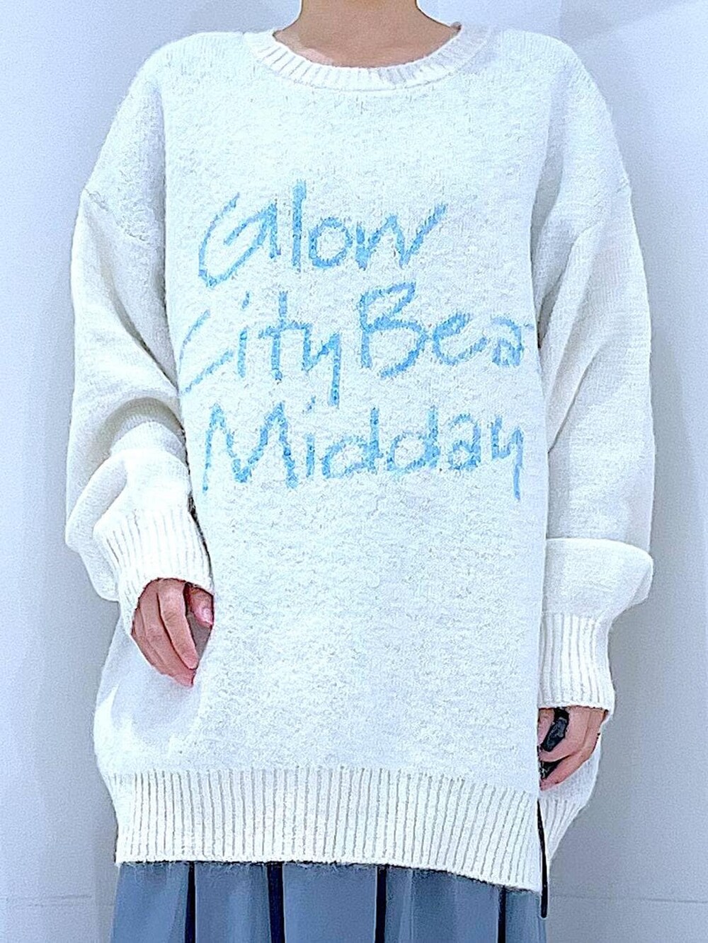 ブラック系のブーツ、ブルー系のスカート、ベージュ系のボストンバッグを着用したレディースの冬コーディネートの7枚目の写真