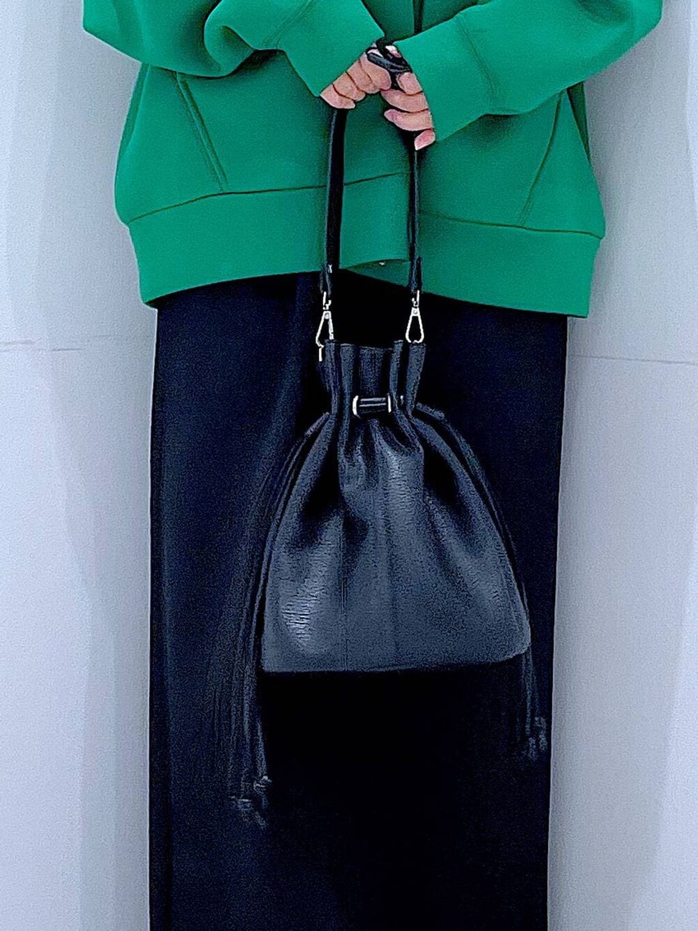 ブラック系のスカート、ブラック系のサンダル、ブラック系のショルダーバッグを着用したレディースの冬コーディネートの9枚目の写真