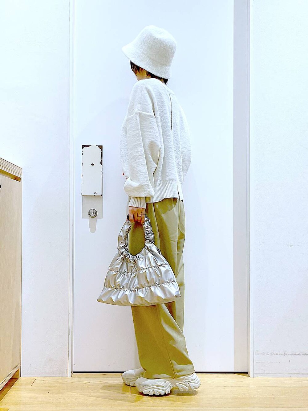 ベージュ系のブーツ、イエロー系のその他パンツ、シルバー系のショルダーバッグを着用したレディースの冬コーディネートの3枚目の写真