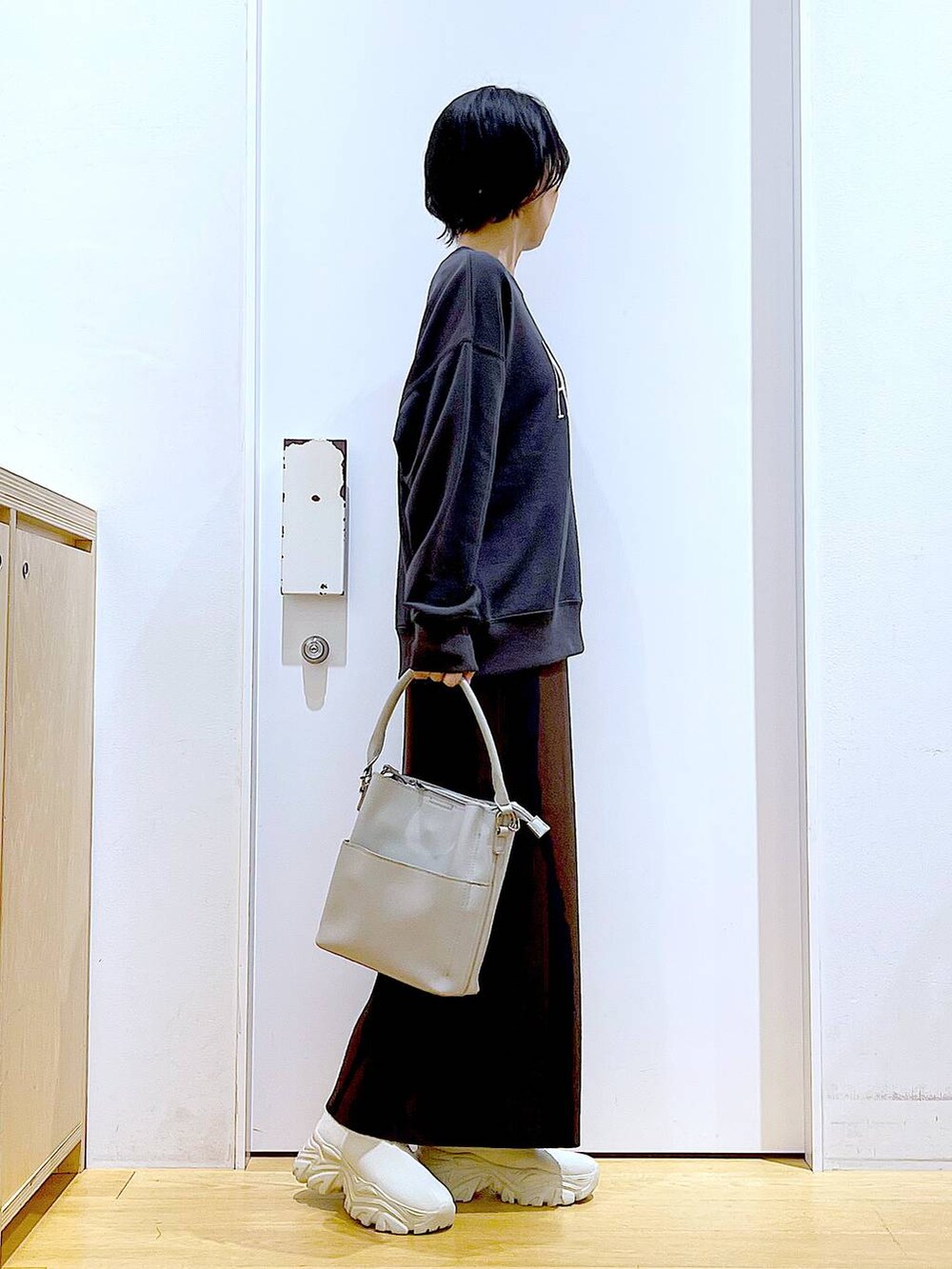 ブラウン系のスカート、グレー系のショルダーバッグ、ベージュ系のブーツを着用したレディースの冬コーディネートの4枚目の写真