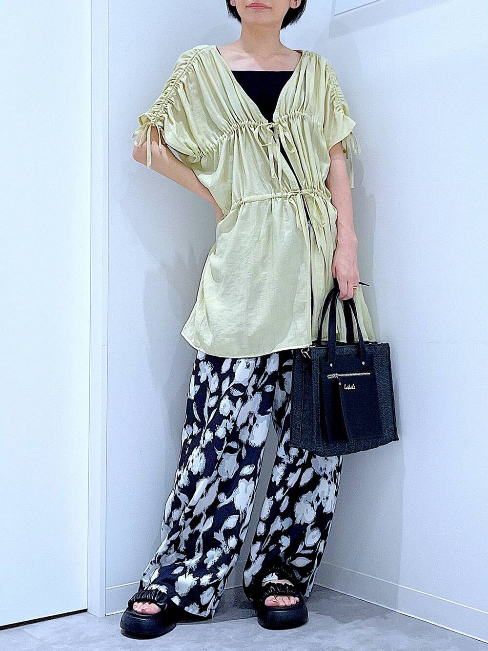 ブラック系のショルダーバッグ、ブラック系のサンダル、ブラック系のその他パンツを着用したレディースの夏コーディネートの6枚目の写真