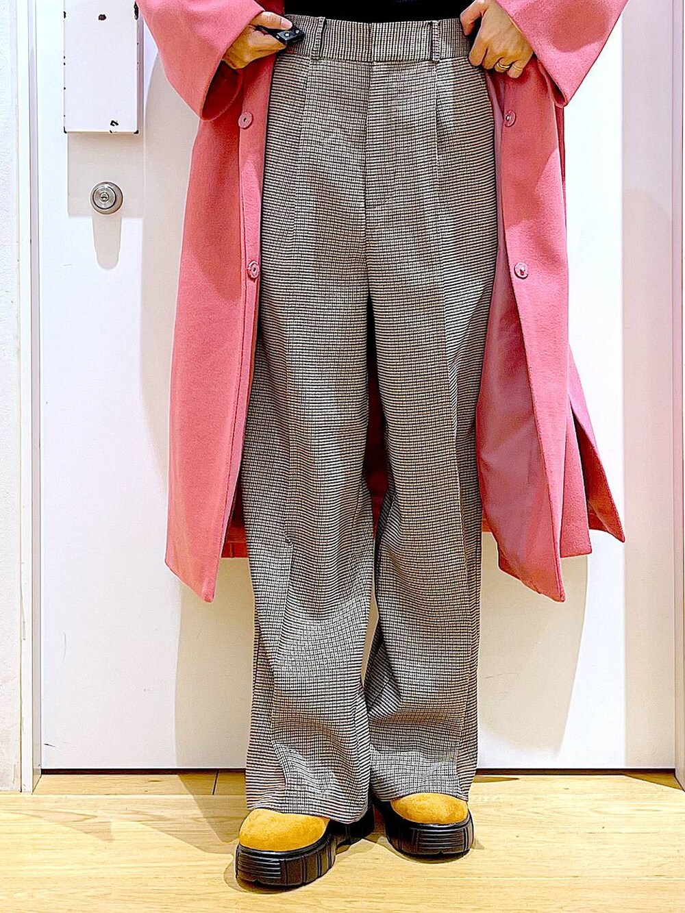 ブラック系のショルダーバッグ、ブラック系のニット/セーター、ベージュ系のスラックスを着用したレディースの冬コーディネートの8枚目の写真