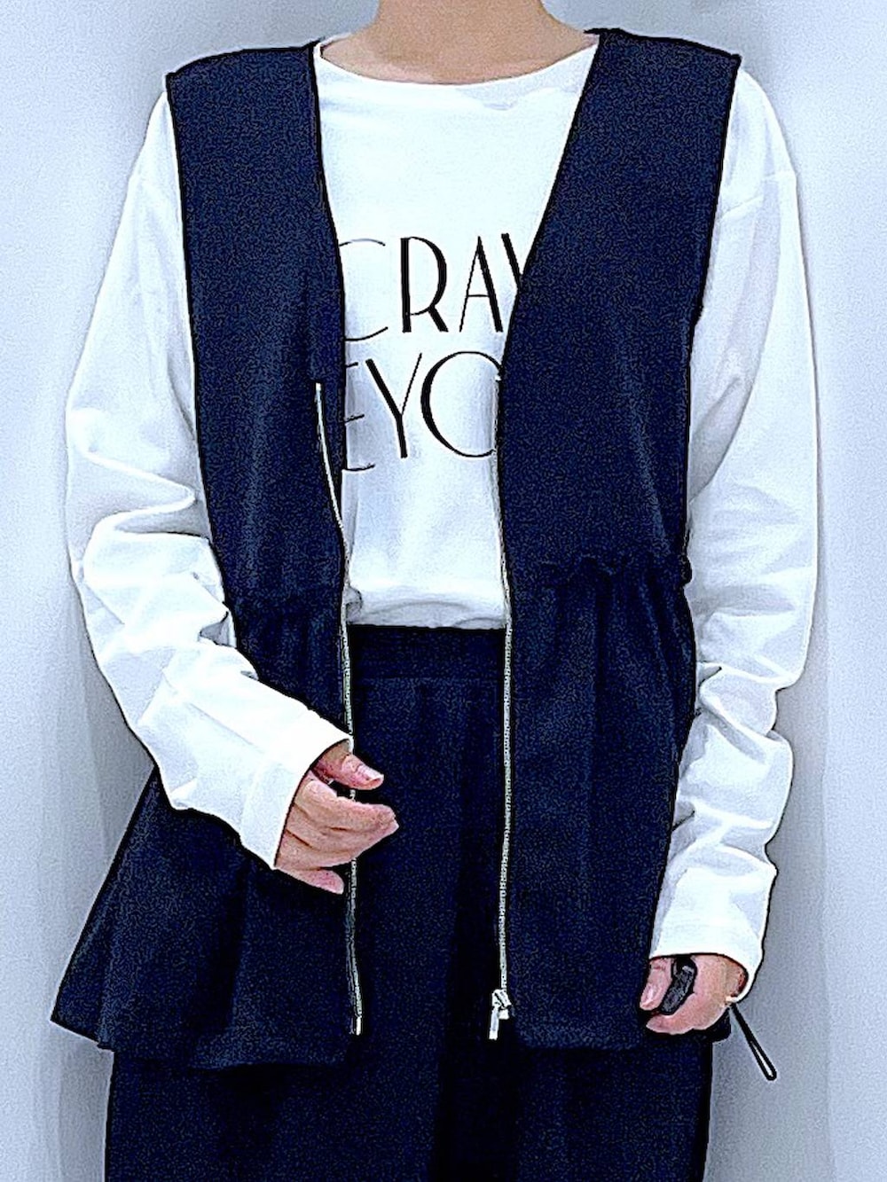 ホワイト系のTシャツ/カットソー、ブラウン系のショルダーバッグ、ブラック系のベストを着用したレディースの秋コーディネートの7枚目の写真