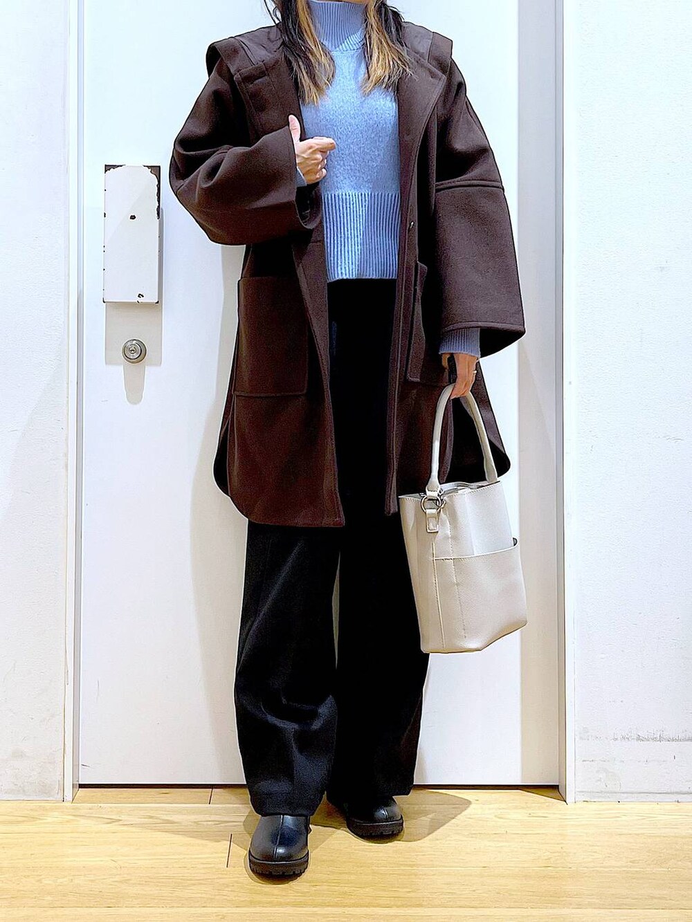 ブラウン系のその他アウター、グレー系のショルダーバッグ、ブラック系のブーツを着用したレディースの冬コーディネートの6枚目の写真