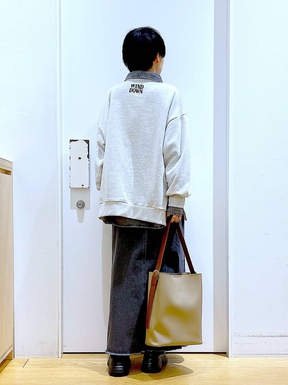 ブラック系のブーツ、グレー系のシャツ/ブラウス、ベージュ系のショルダーバッグを着用したレディースの春コーディネートの5枚目の写真