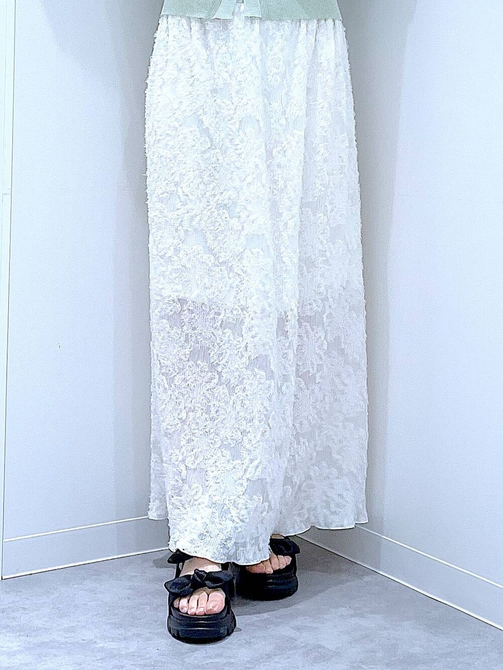 ブラック系のサンダル、ホワイト系のスカート、グリーン系のカーディガン/ボレロを着用したレディースの夏コーディネートの8枚目の写真