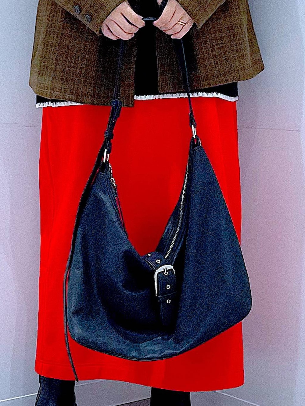 レッド系のスカート、ブラック系のブーツ、ブラック系のショルダーバッグを着用したレディースの冬コーディネートの9枚目の写真