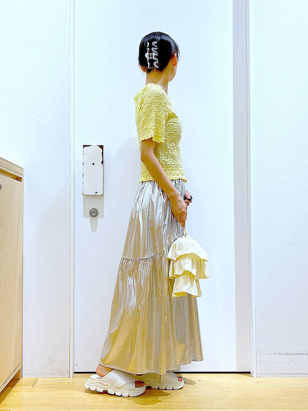 ホワイト系のサンダル、シルバー系のスカート、イエロー系のカーディガン/ボレロを着用したレディースの夏コーディネートの4枚目の写真