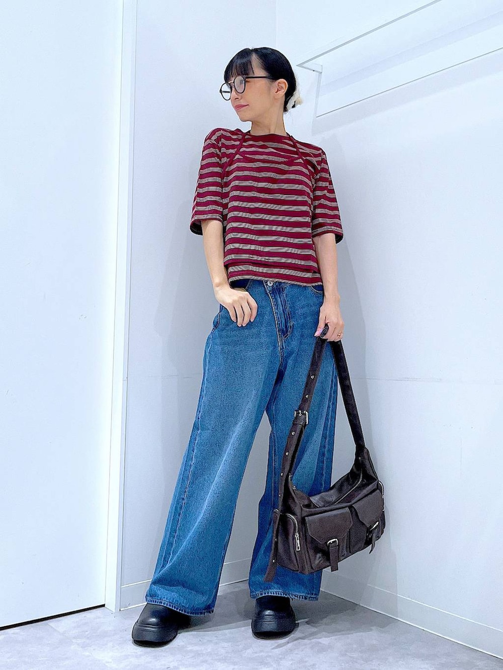ブルー系のデニムパンツ、レッド系のTシャツ/カットソー、ブラック系のその他シューズを着用したレディースの秋コーディネートの2枚目の写真