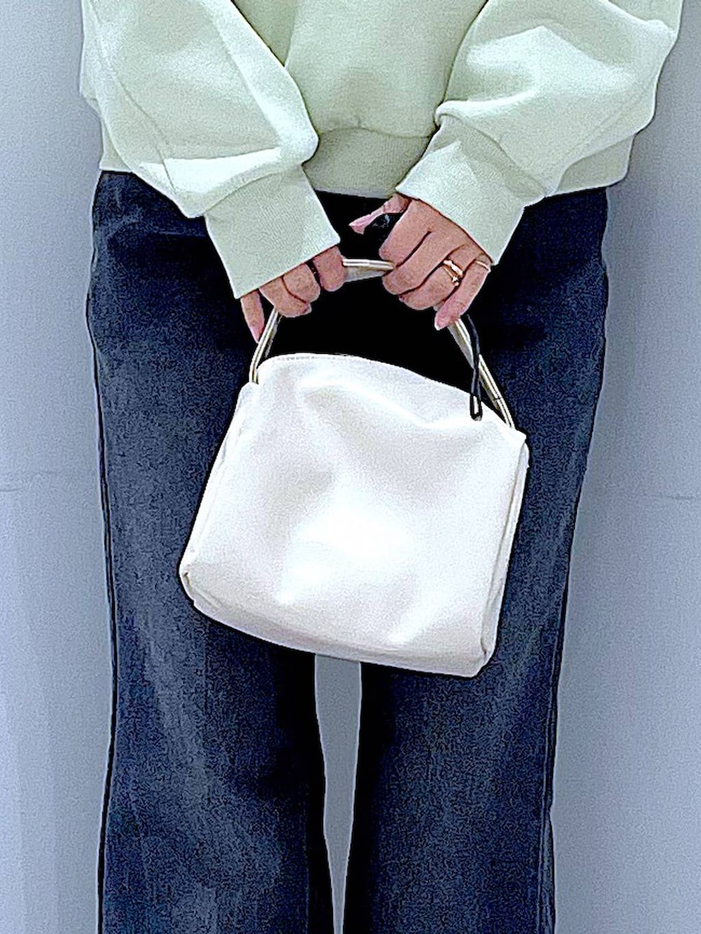 ホワイト系のショルダーバッグ、グリーン系のスウェット、ブラック系のデニムパンツを着用したレディースの春コーディネートの9枚目の写真