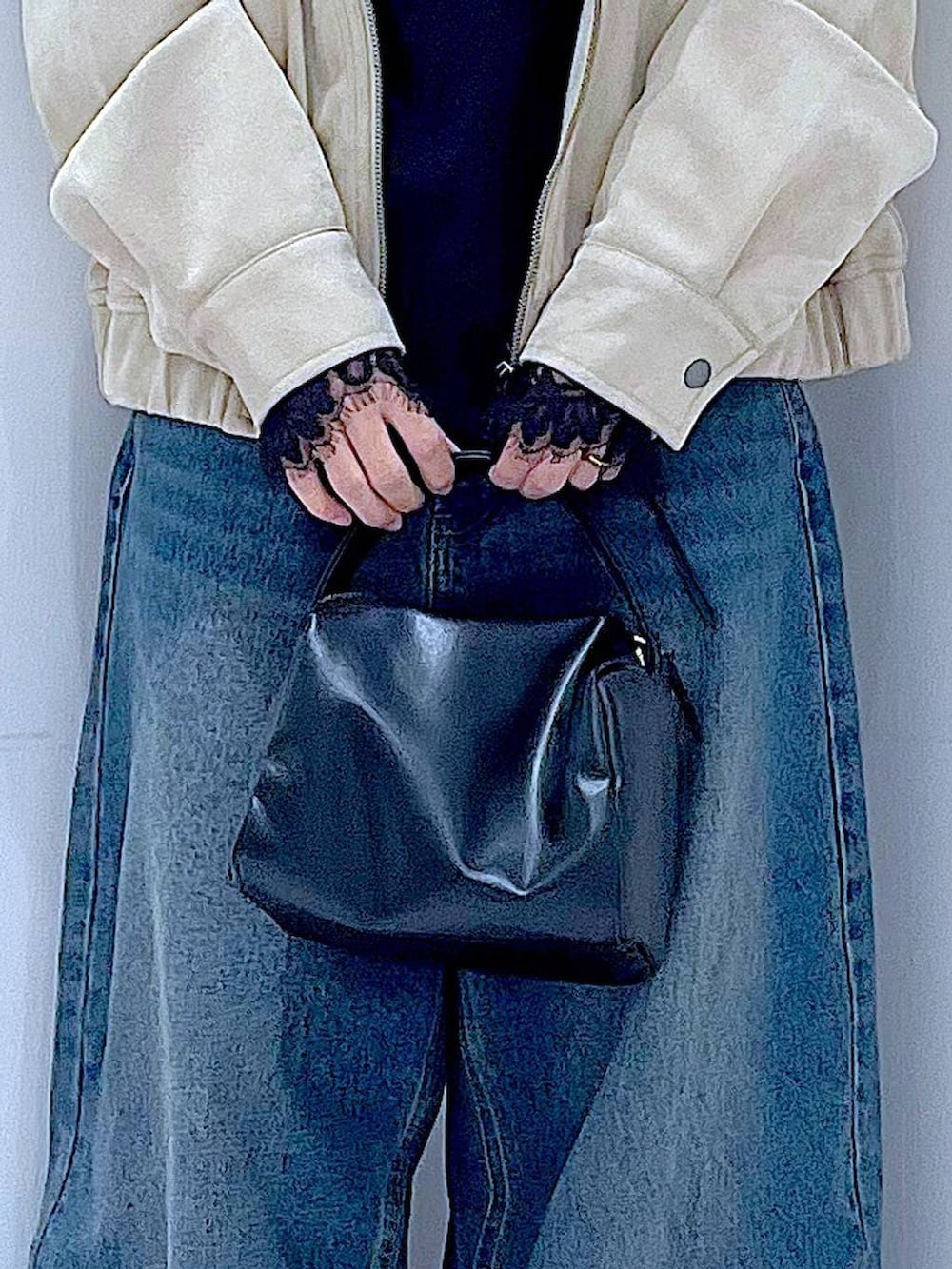 ブルー系のデニムパンツ、ブラック系のショルダーバッグ、ベージュ系のブルゾンを着用したレディースの春コーディネートの9枚目の写真