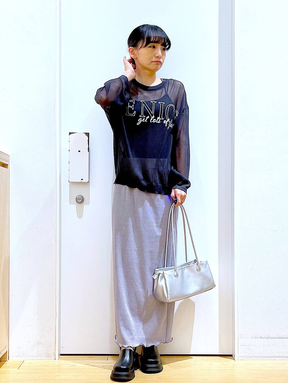 パープル系のスカート、ブラック系のサンダル、グレー系のニット/セーターを着用したレディースの春コーディネートの2枚目の写真