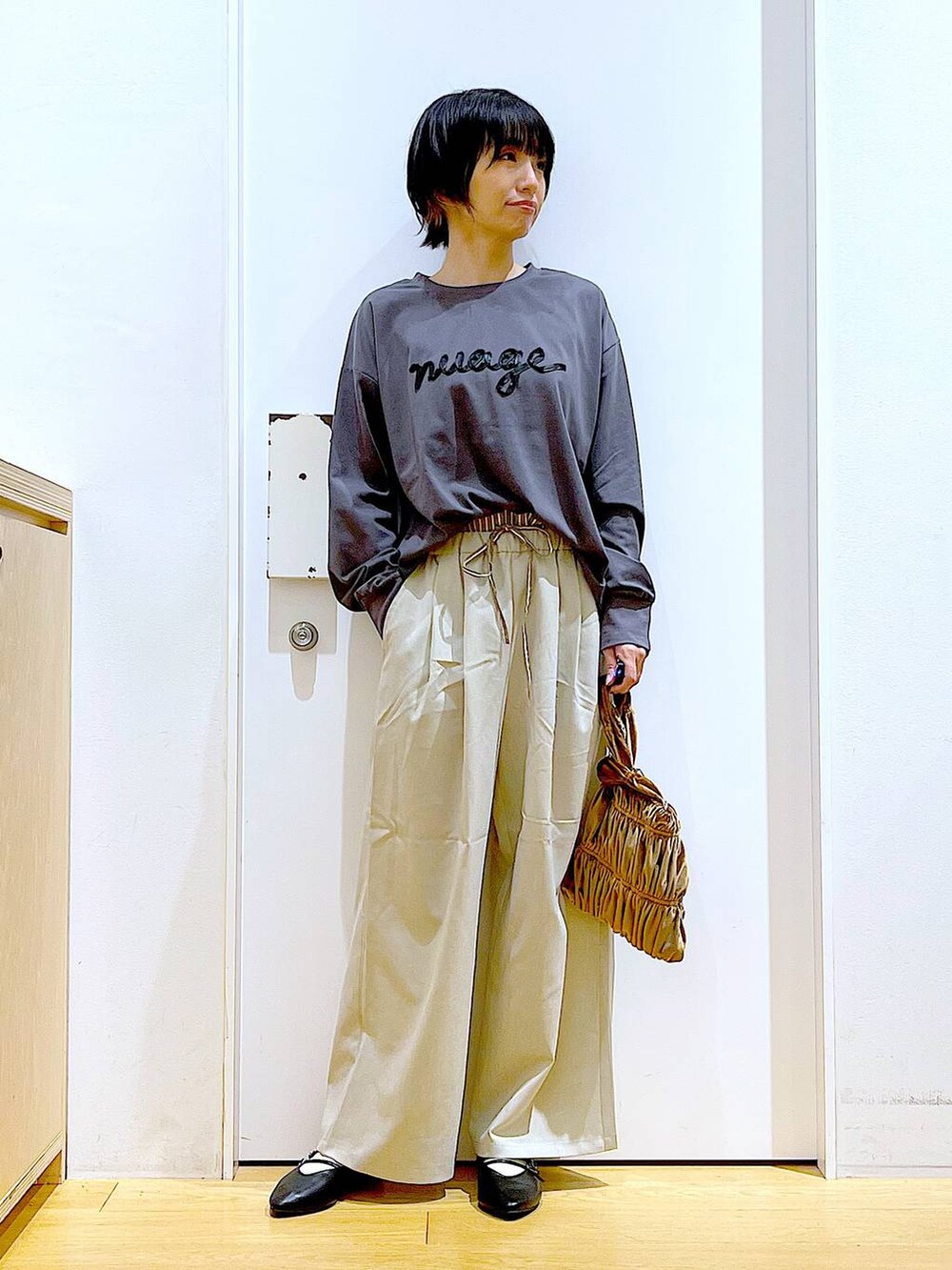 ブラック系のパンプス、イエロー系のショルダーバッグ、ベージュ系のその他パンツを着用したレディースの秋コーディネートの2枚目の写真