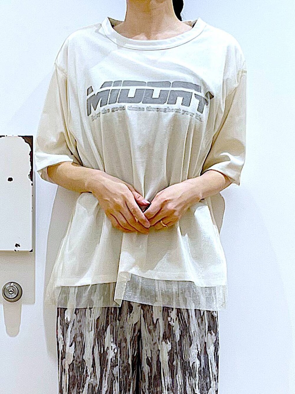 ホワイト系のTシャツ/カットソー、ブラック系のパンプス、ベージュ系のショルダーバッグを着用したレディースの夏コーディネートの7枚目の写真