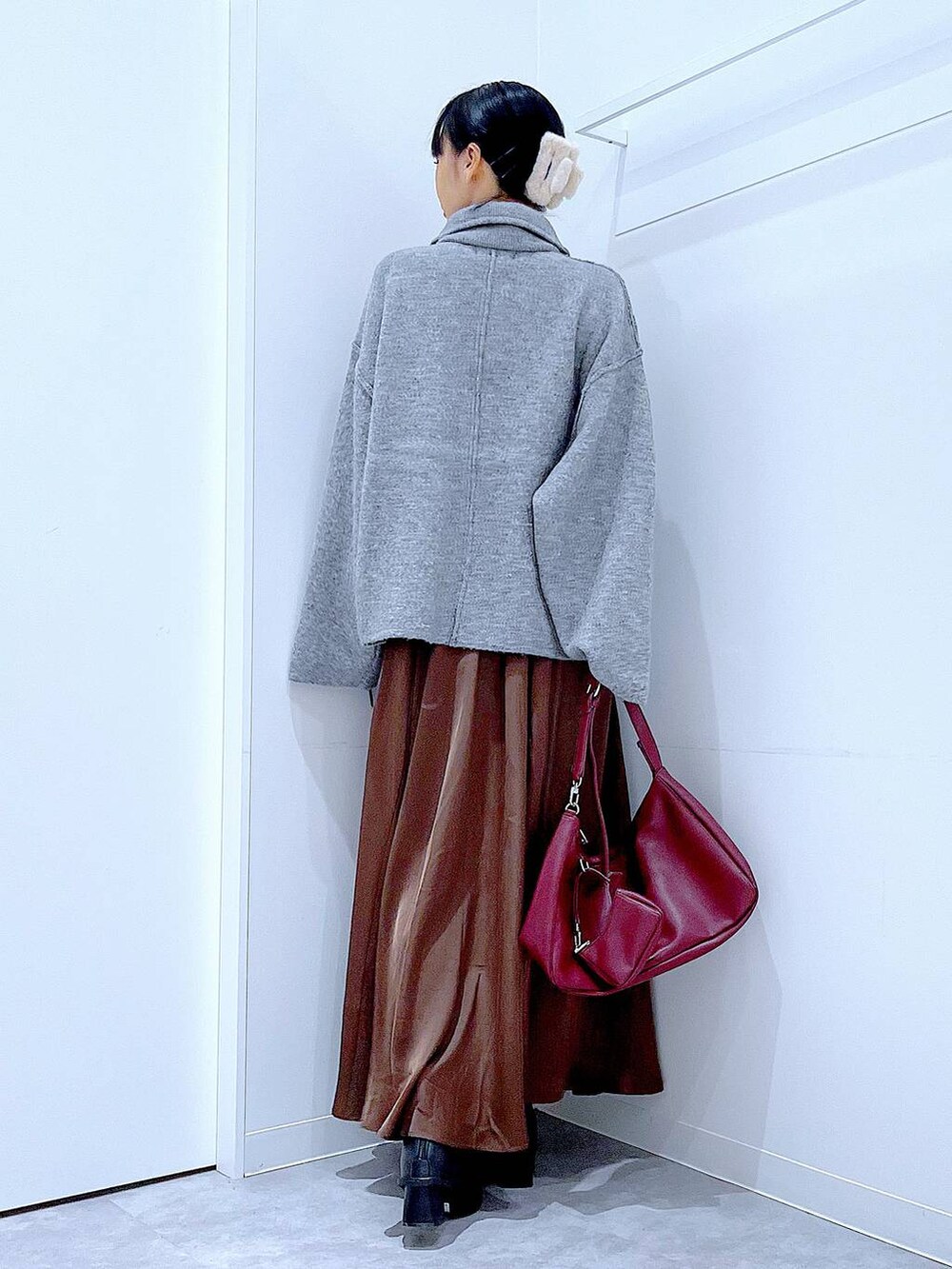 グレー系のブルゾン、ブラック系のブーツ、レッド系のショルダーバッグを着用したレディースの冬コーディネートの5枚目の写真