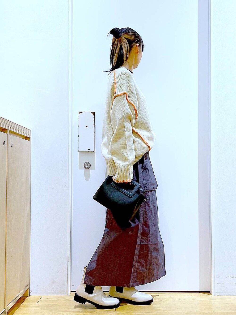 ブラック系のTシャツ/カットソー、ベージュ系のブーツ、ブラック系のショルダーバッグを着用したレディースの冬コーディネートの4枚目の写真