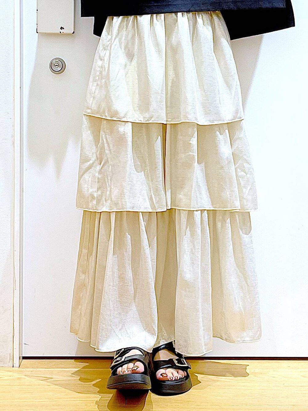 ブラック系のサンダル、ブラック系のショルダーバッグ、ゴールド系のスカートを着用したレディースの夏コーディネートの8枚目の写真