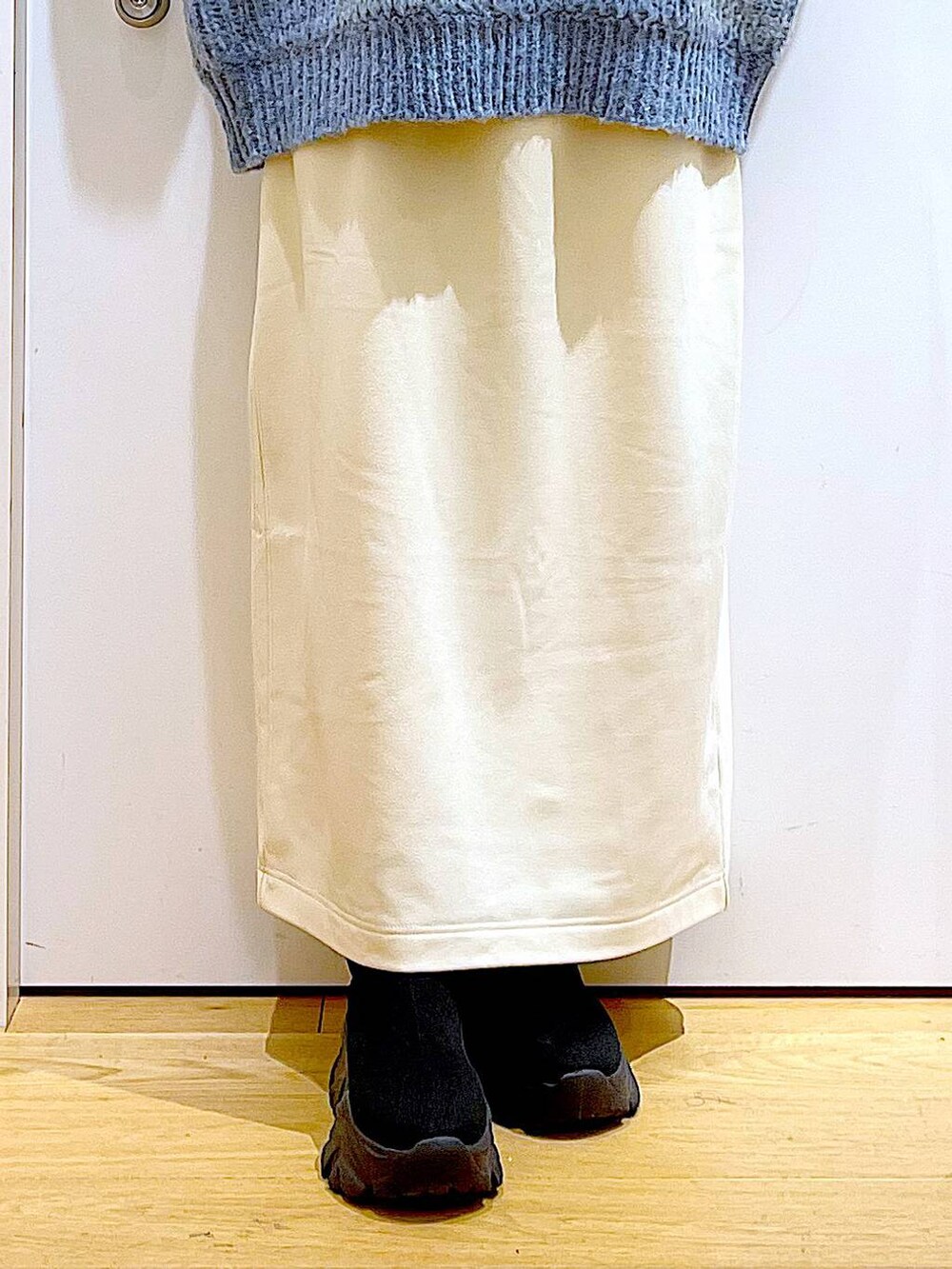 グレー系のショルダーバッグ、オレンジ系のニット/セーター、ブラック系のブーツを着用したレディースの冬コーディネートの8枚目の写真