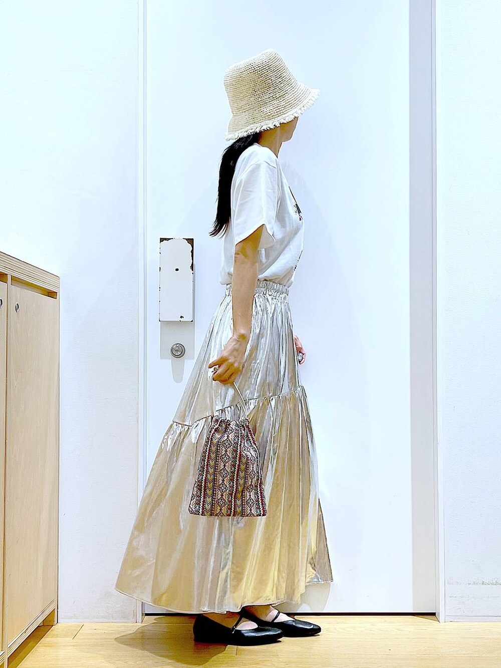 ピンク系のショルダーバッグ、シルバー系のスカート、ホワイト系のTシャツ/カットソーを着用したレディースの夏コーディネートの4枚目の写真