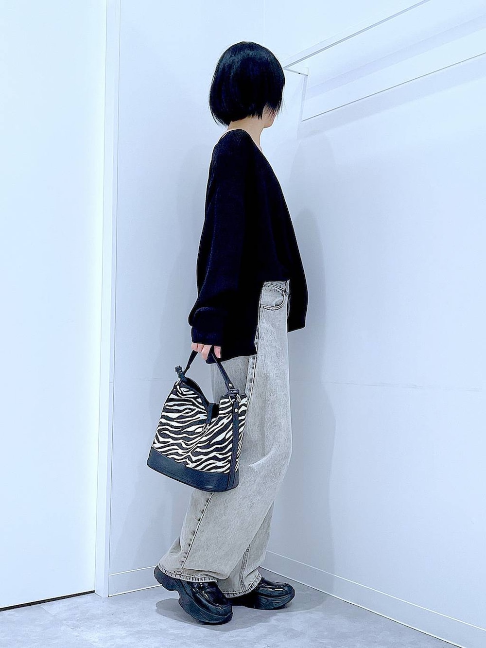 ベージュ系のデニムパンツ、ブラック系のローファー、その他のショルダーバッグを着用したレディースの秋コーディネートの4枚目の写真